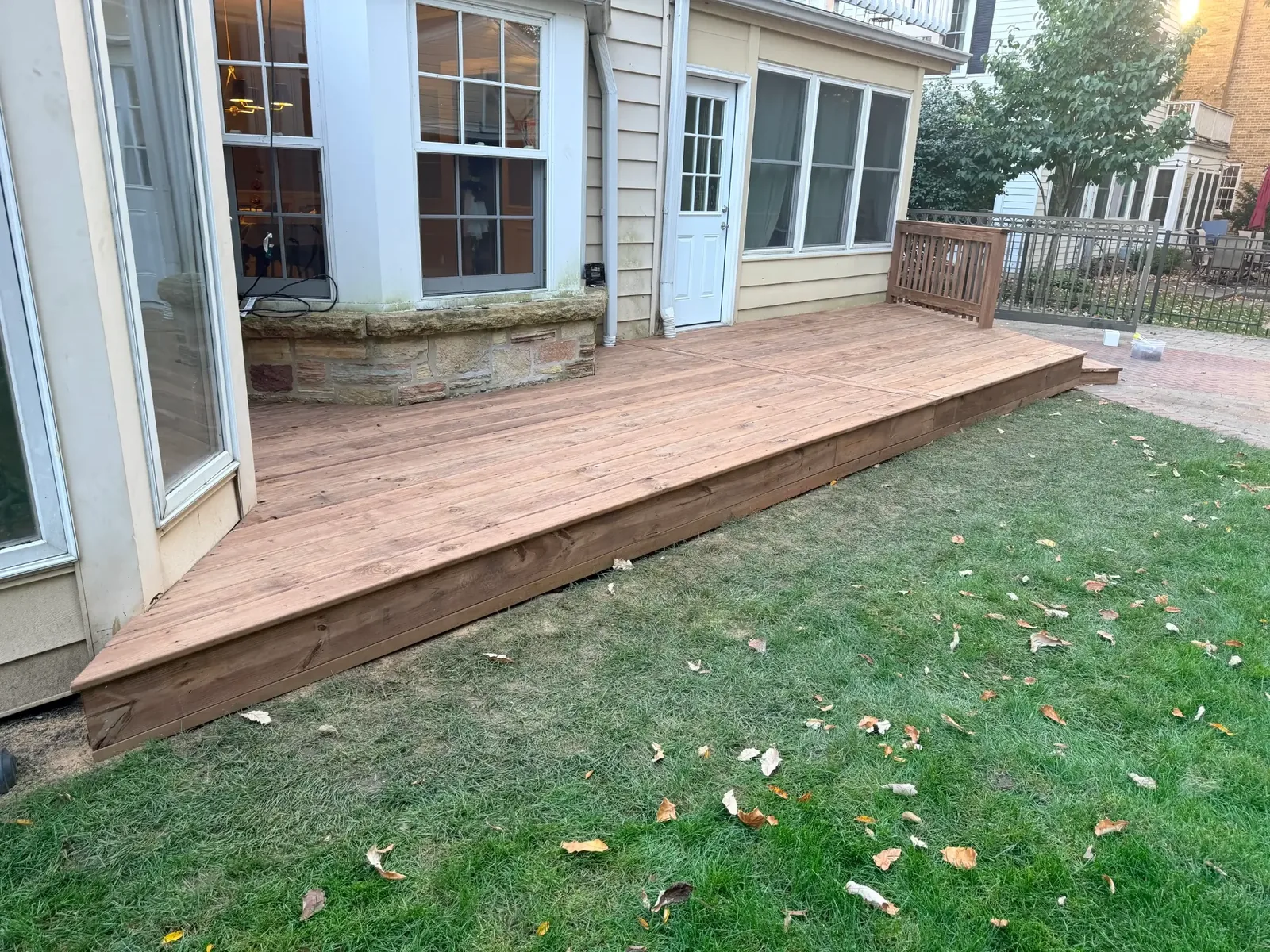 Cedartone deck boards and wood fascia along the garden edge of the deck