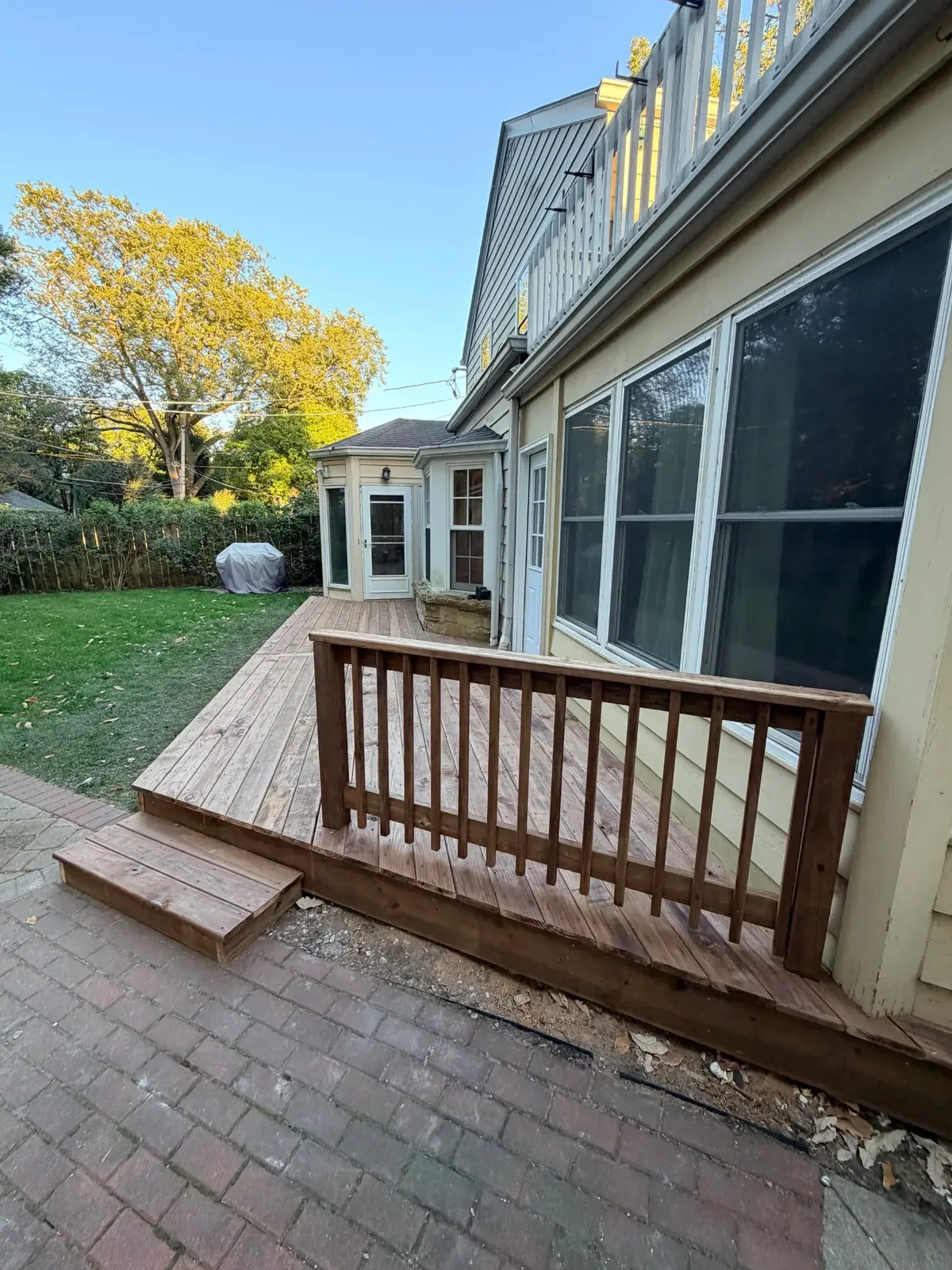Vertical view of the wood railing, deck edge and step beside the patio