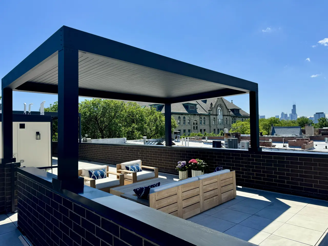 Louvered pergola and seating on a Chicago rooftop terrace with the skyline in view